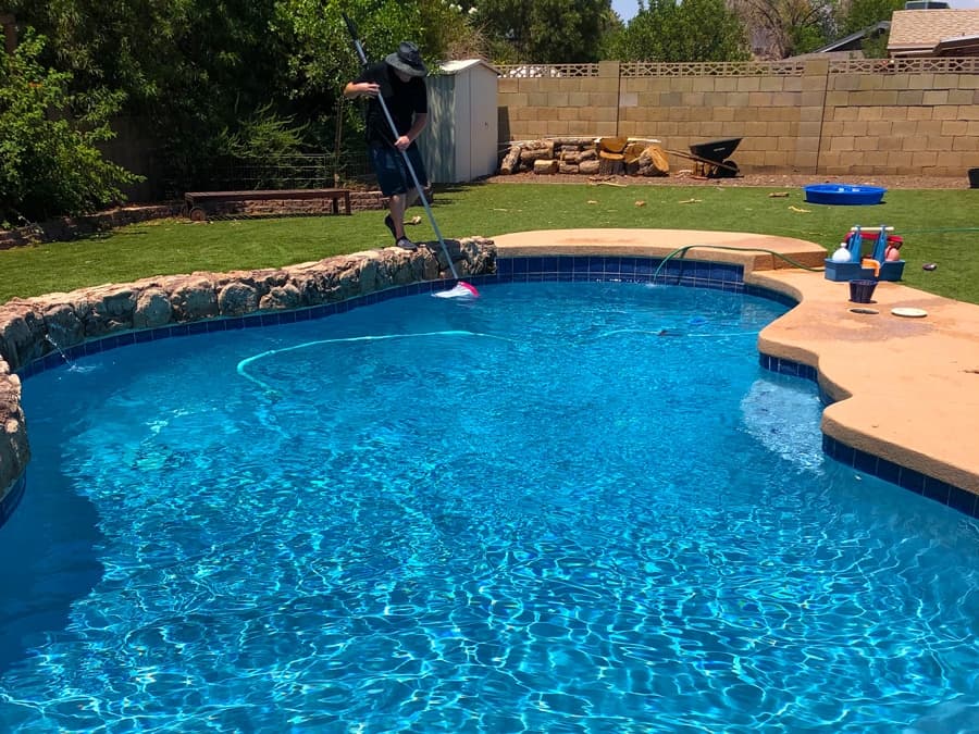 Pool technician testing water chemistry to keep the pool crystal clear
